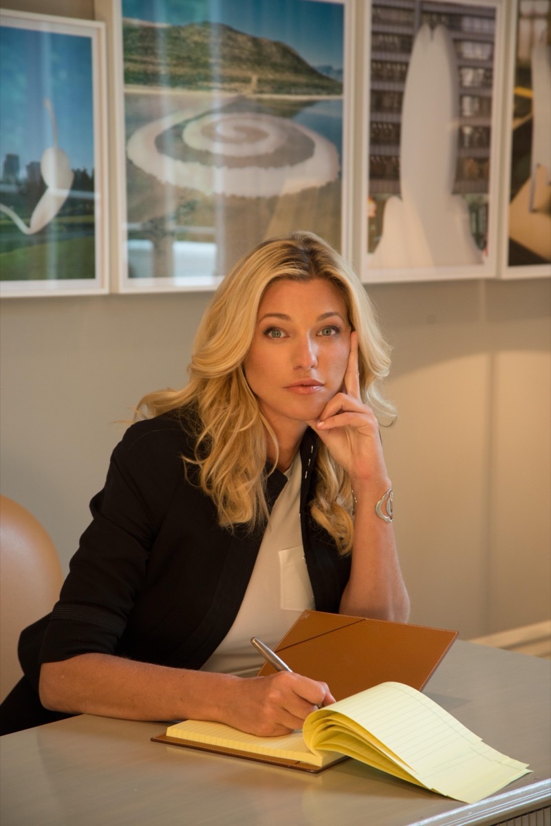 Nicole Junkermann scrive su un taccuino a una scrivania in una luce calda